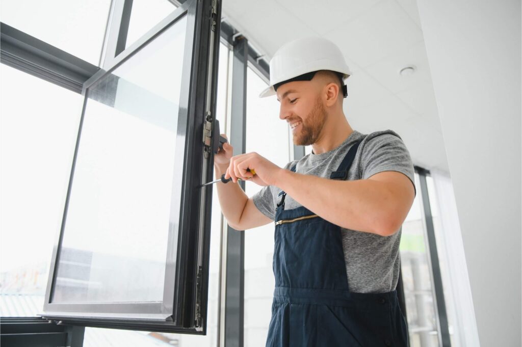 Expert fixing broken window frame during door repair in Dubai