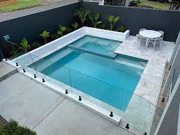 Secure and stylish swimming pool glass fence in Dubai with unobstructed outdoor view.